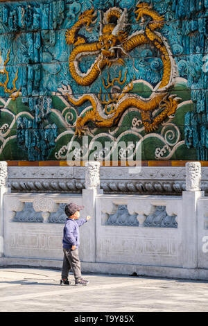 Einen kleinen chinesischen Jungen vor der schönen Drachen in der Verbotenen Stadt in Peking, China Stockfoto