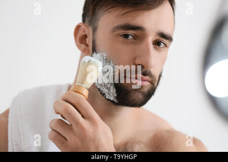 Schöner mann Rasieren im Badezimmer Stockfoto