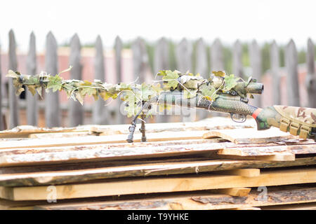 Camouflage schwarz Gewehr im Freien auf Leiterplatten. Armee, Militär, airsoft Hobby Stockfoto