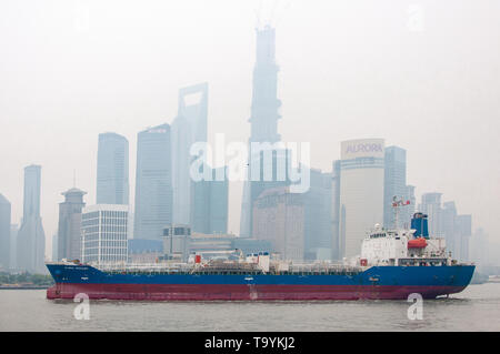 SHANGHAI, China - 12 Apr 2013: Cargo Schiff segelt vor dem Hintergrund der Wolkenkratzer von Shanghai Stockfoto