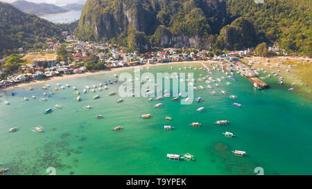 Viele Boote in die türkisfarbene Lagune. Meereslandschaft mit Blue Bay und Boote Blick von oben. El Nido, Palawan, Philippinen. Traditionelle philippinische Holz- Auslegerboot, das die Banca genannt. Sommer und Reisen Urlaub Begriff Stockfoto