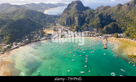 Viele Boote in die türkisfarbene Lagune. Meereslandschaft mit Blue Bay und Boote Blick von oben. El Nido, Palawan, Philippinen. Traditionelle philippinische Holz- Auslegerboot, das die Banca genannt. Sommer und Reisen Urlaub Begriff Stockfoto