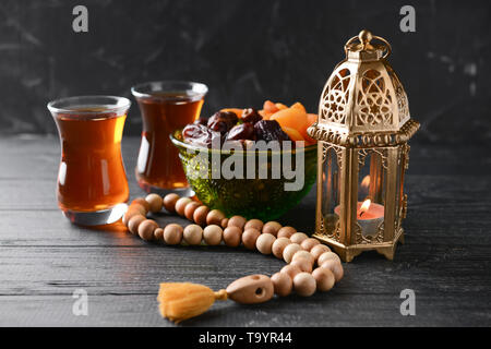 Muslimische Lampe, getrocknete Früchte, Kaffee und tasbih auf hölzernen Tisch Stockfoto