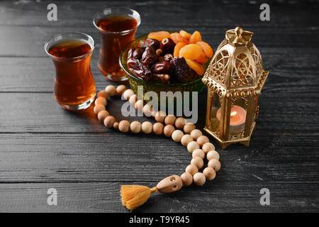 Muslimische Lampe, getrocknete Früchte, Kaffee und tasbih auf hölzernen Tisch Stockfoto