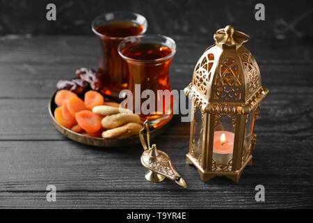 Muslimische Lampen, getrocknete Früchte und Tee auf hölzernen Tisch Stockfoto