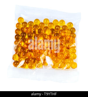 Orange sphärischen Kugel Kapseln mit Fischöl in der Plastiktüte auf weißem Hintergrund. Stockfoto