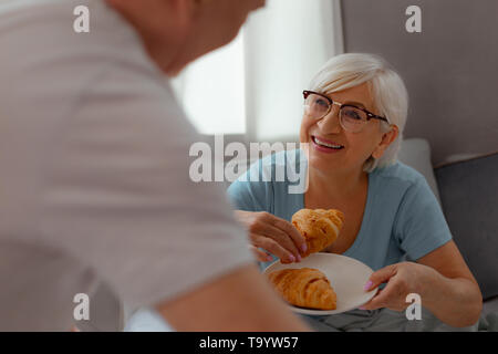 Gesicht - Porträt der Lady Vorbereiten eines frisch gebackenen croissant Essen Stockfoto