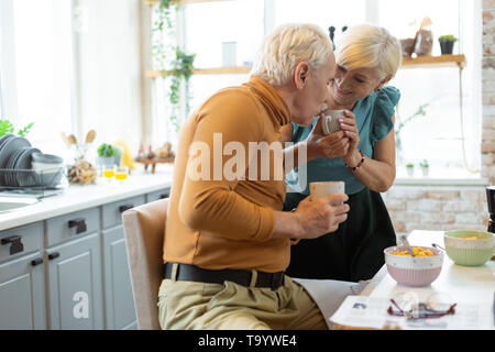 Lieben, fürsorglichen Mann küssen die Hand seiner älteren Frau Stockfoto