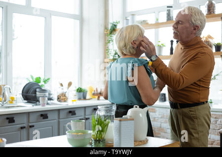 Liebevoller Mann zärtlich berühren das Gesicht der charmante elegante Frau. Stockfoto