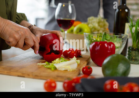 Nahaufnahme der weiblichen Schneiden rot Peeper für das Abendessen Stockfoto