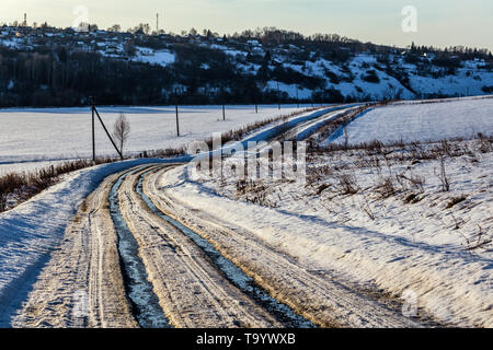 Rustikale Straßenpiste im Winter tauen Tageslicht auf, ohne dass jemand dabei ist Stockfoto