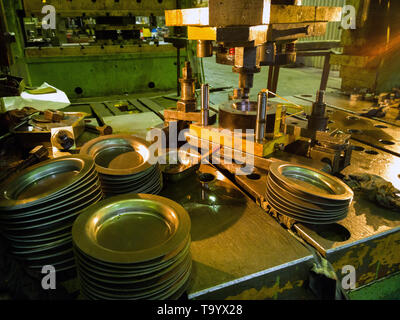 Low-Tech-Stanzpresse, die runde Aliumteile in dunkler Umgebung herstellt Stockfoto