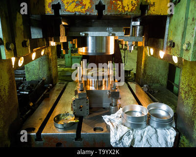 Verschmutzte gebrauchte Low-Tech-Stanzpresse, die runde Aliumteile herstellt Stockfoto