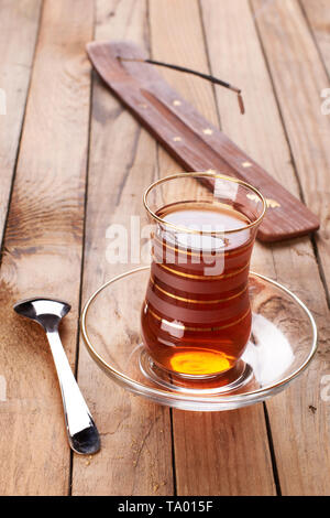Türkischer Apfeltee in traditionellen Glas und Platte auf Holz- Hintergrund Stockfoto