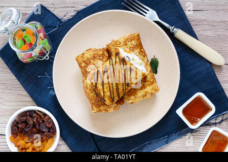 Köstlich zarte Pfannkuchen mit Hüttenkäse, Vanille und Rosinen auf einem Teller. Gesundes Frühstück. Ansicht von oben. Stockfoto