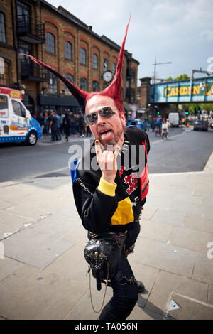 London/Großbritannien - 18. Mai 2019: ein Mann im Punk Kleidung und mit pfennigabsatz Haar gekleidet posiert für die Kamera auf der Camden High Street, Camden Town, London. Stockfoto