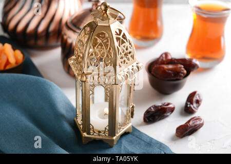 Muslimische Laterne mit getrockneten Datteln auf Tisch Stockfoto