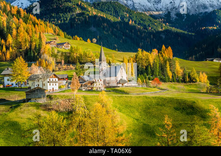 Traditionelle alpine Village in den Dolomiten herzlich beleuchtet nach einer untergehenden Sonne im Herbst Stockfoto