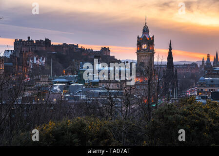 Winter Sonnenuntergang über der Altstadt von Edinburgh übersehen durch das Schloss. Aclock Turm ist im Vordergrund sichtbar. Stockfoto