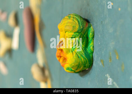 Blau Kletterwand mit bunten Klettern hält Rock in der Turnhalle Stockfoto