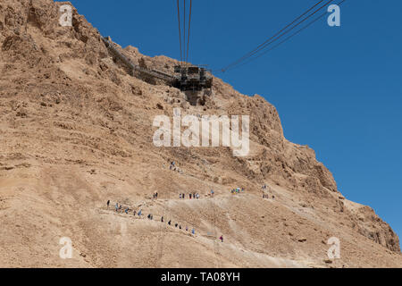 Israel, historischen Masada aka Massada. Seilbahn auf den Gipfel des Masada. Touristen wandern bis zum Gipfel auf der Schlange Weg in der Ferne. Stockfoto