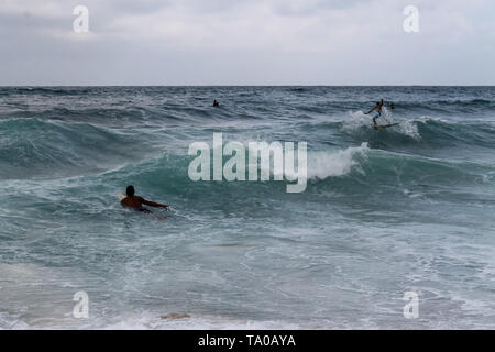 Youn Männer surfen grobe Monsun Wellen an Juara Beach auf Tioman Insel, Malaysia Stockfoto