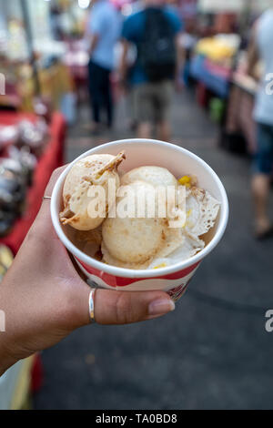 Kanom Krok, die typischen thailändischen coconut Pfannkuchen in die Hand einer Frau auf dem Nachtmarkt in Chiang Mai, Thailand Stockfoto