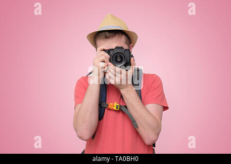 Junge touristische Mann unter Foto mit dslr bei Camera suchen Stockfoto