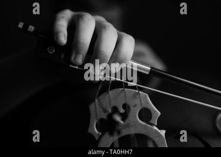 Ein junger Cellist Praktiken intensiv auf seinem Cello, gesehen von der Brücke und Bug Seite Stockfoto