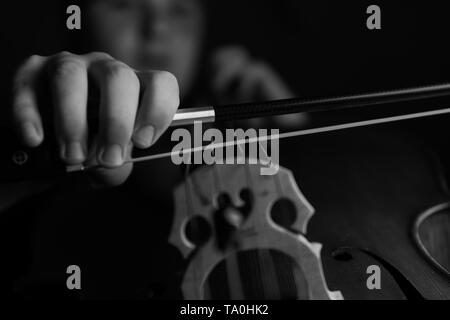 Ein junger Cellist Praktiken intensiv auf seinem Cello, gesehen von der Brücke und Bug Seite Stockfoto