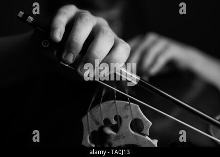 Ein junger Cellist Praktiken intensiv auf seinem Cello, gesehen von der Brücke und Bug Seite Stockfoto