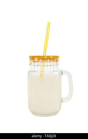 Marmeladenglas mit gestreiften Kunststoffrohr mit Milch auf weißem Hintergrund. Konzept der Welt Milch Tag, richtige gesunde Ernährung. Von der Seite. Stockfoto