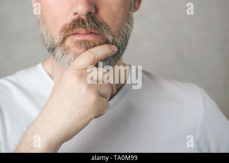 Nachdenklich reifer Mann Portrait auf grauem Hintergrund Stockfoto