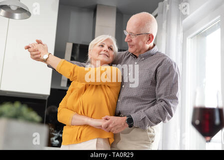 Senior Paar tanzen und zu Hause ein Lächeln auf den Lippen. Glückliches Paar der Rentner Stockfoto