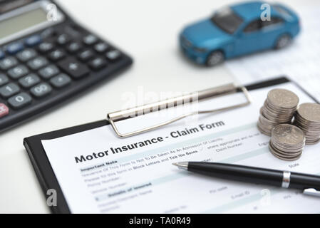Motor oder car insurance claim Form mit coin stack, der Rechner und der Pkw-Modell. Stockfoto
