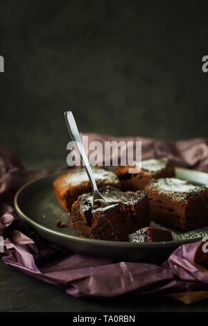 Stück lecker vegan Milchfrei dark chocolate brownies Dessert oder Square feuchten Schwamm Kuchen ohne Eier gekocht und mit Puderzucker eingerichtet Stockfoto