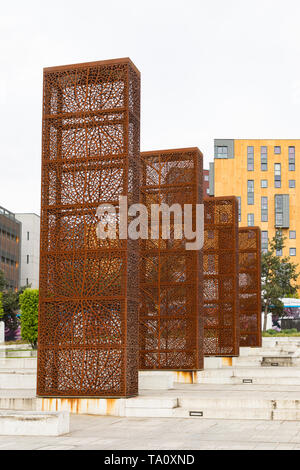 Birmingham, West Midlands, Großbritannien: Vier monolith geformte Metallskulpturen mit filigranen Blattentwürfen im Stadtzentrum von Eastside City Park. Stockfoto