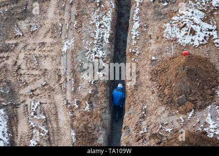 Blick von oben auf ein Arbeitnehmer im Graben an der Baustelle Stockfoto