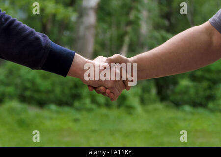 Männer Hände schütteln. Unternehmer handshaking nach guter Deal. Konzept des erfolgreichen Business Partnerschaft treffen. Halten sich an den Händen. Nahaufnahme auf Green n Stockfoto