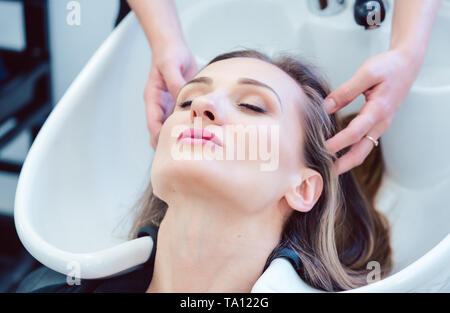 Waschen Friseur Haar von Client in Ihrem Shop Stockfoto