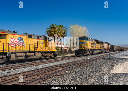 Ein Güterzug an einer Kreuzung in der Mojave-Wüste, Kalifornien, USA. Stockfoto