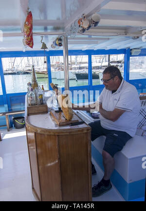 PALMA, MALLORCA, SPANIEN - 20. MAI 2019: Schinken schneiden von synthetischen jamonero auf Tour Boot am 20. Mai 2019 im Palma, Mallorca, Balearen, Spanien. Stockfoto