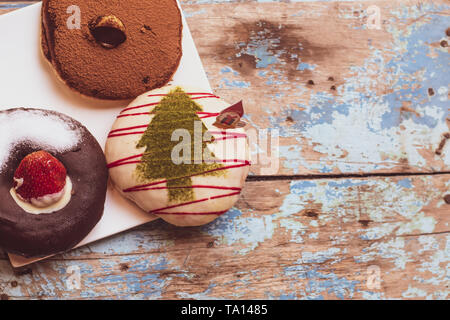 Die Bunte runde Donuts auf der hölzernen Tisch blau lackiert Hintergrund Party Idee Stockfoto