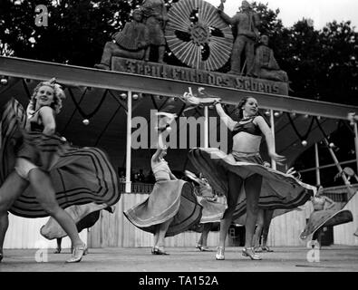 Bei einem Volksfest der NS-Organisation "Kraft duch Freude" in Treptow, das Festival Besucher sind mit einem Ballett des Theater des Volkes (Theater des Volkes) aus Berlin unterhalten zu werden. Im Hintergrund, eine Tribüne mit einem Music Orchestra. Oben, das Emblem der KdF und der Slogan "Freut euch des Lebens" ( "das Leben genießen"). Stockfoto