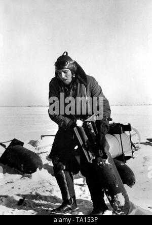 Ein Besatzungsmitglied unterstützt die Bodenmannschaft beim Laden des Kampfflugzeugs, indem eine Bombe zu sein Flugzeug. Foto der Propaganda Firma (PK): kriegsberichterstatter Schuller Stockfoto