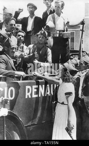Foto von einer Gruppe von freiwilligen Milizsoldaten loyal gegenüber der Regierung in einem Renault Auto in Madrid kurz nach dem Ausbruch des Spanischen Bürgerkrieges am 29. Juli 1936. Die Kämpfer, die in der Uniform oder Zivilkleidung, Paddles und Gewehre. An der Vorderseite des Autos, eine junge Frau steht in einem weißen Kleid mit einem gorillo Hut und eine Pistole in der Hand. Die Freiwilligen sollen die republikanischen Truppen in die Kämpfe in der Sierra Guadarrama im Norden von Madrid zu unterstützen. Stockfoto
