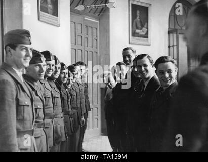 Undatiertes Foto von einer Gruppe der Legionäre der Legion Condor (auf der linken Seite in Uniform), der gerade in Spanien angekommen sind, und eine Gruppe von Soldaten, die wieder nach Deutschland kommen (auf der rechten Seite in ziviler Kleidung) in einer Baracke der Truppe in 1939. Stockfoto