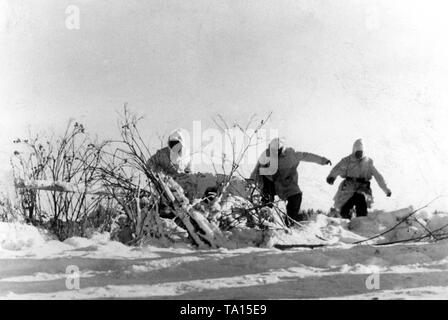 A Gun Crew ist auf dem Weg zu einer nahezu Schneebedeckten anti-tank Gun (vermutlich ein 5-cm-PaK 38). Foto der Propaganda Firma (PK): SS Kriegsberichterstatter Tufts. Stockfoto