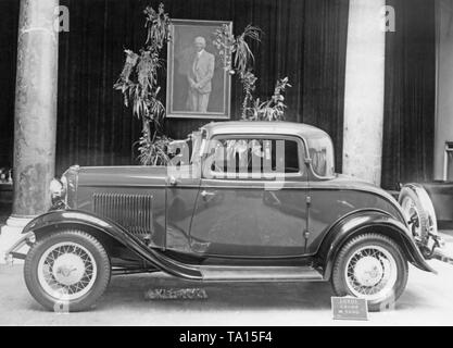 Ford Deutschland: Präsentation eines 8-Zylinder Coupé Modell 18 in Köln. Im Hintergrund ist ein Portrait von Henry Ford. Stockfoto