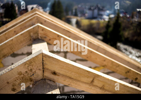 Close-up Detail der Dachrahmen aus grobem Holz Bauholz Balken auf dem Hintergrund von Misty Mountain Landschaft im ökologischen Bereich. Gebäude, Dach, constructi Stockfoto